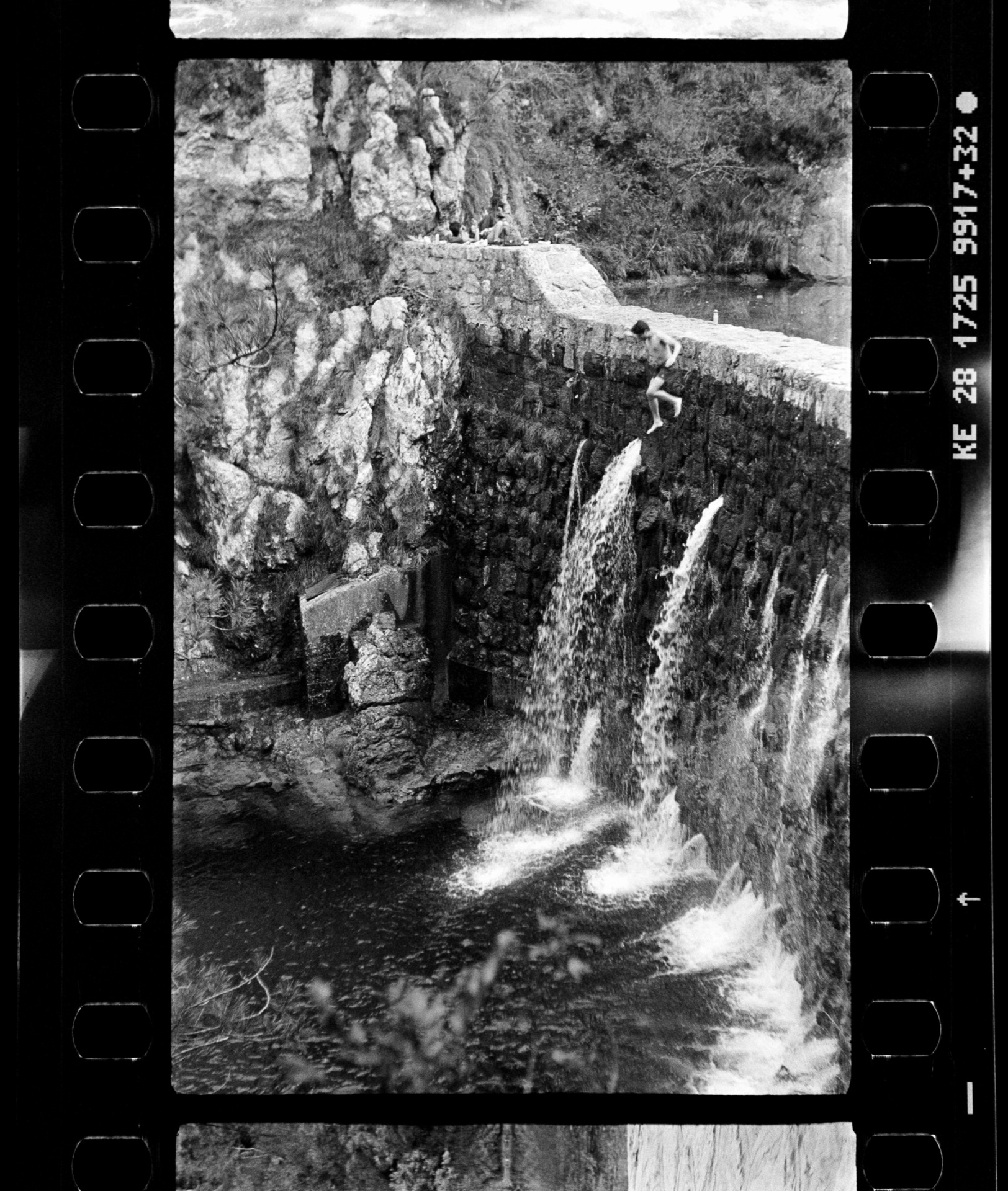 Boy diving from a waterfall dam, shot on film, black and white